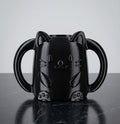 Glossy black 3D printed cat juice box holder with dual handles to prevent kids squeezing drinks